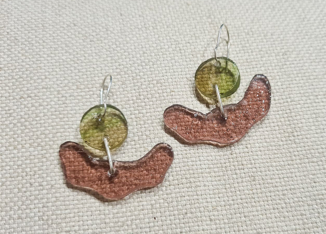 Ces boucles d’oreilles présentent une forme amusante tout en courbes dans un verre rose bullé, surmonté d’un disque vert strié de rose. Elles sont agrémentées d’attaches crochet en laiton argenté.