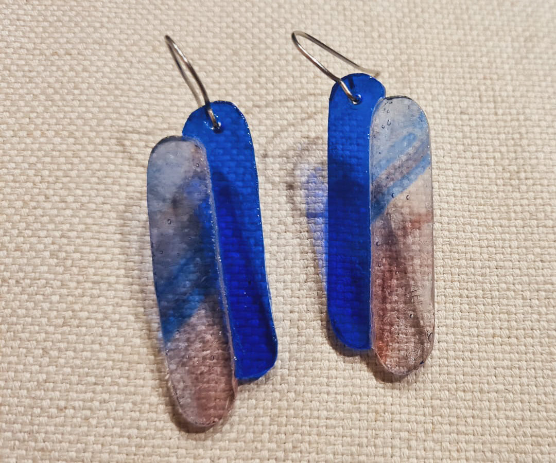 Ces boucles d’oreilles présentent deux verres de forme oblongue. L’un est bleu cobalt et l’autre présente un mélange de volutes rosées et bleutées sur fond clair. Le verre présente des bulles qui concourent à son charme :) Elles sont agrémentées d’attaches crochet en acier chirurgical. 