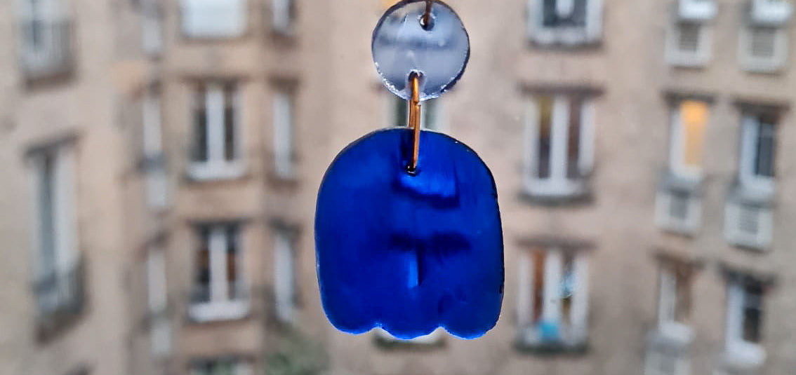 Ces boucles d’oreilles présentent un disque bleu clair qui surmonte une forme toute en courbes. Des gravures griffées ont été ajoutées dans le verre bleu cobalt. Elles sont agrémentées d’attaches crochet en laiton argenté. 