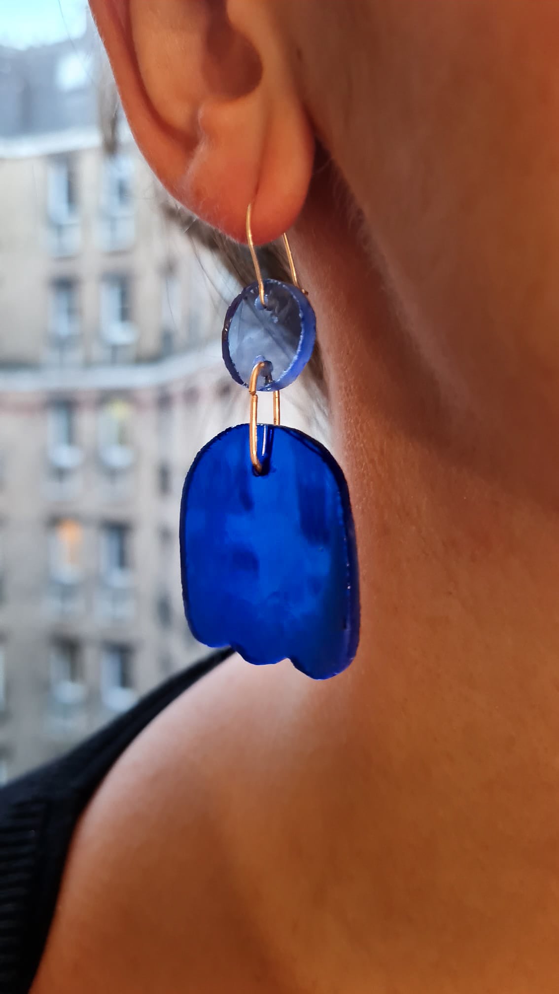 Ces boucles d’oreilles présentent un disque bleu clair qui surmonte une forme toute en courbes. Des gravures griffées ont été ajoutées dans le verre bleu cobalt. Elles sont agrémentées d’attaches crochet en laiton argenté. 